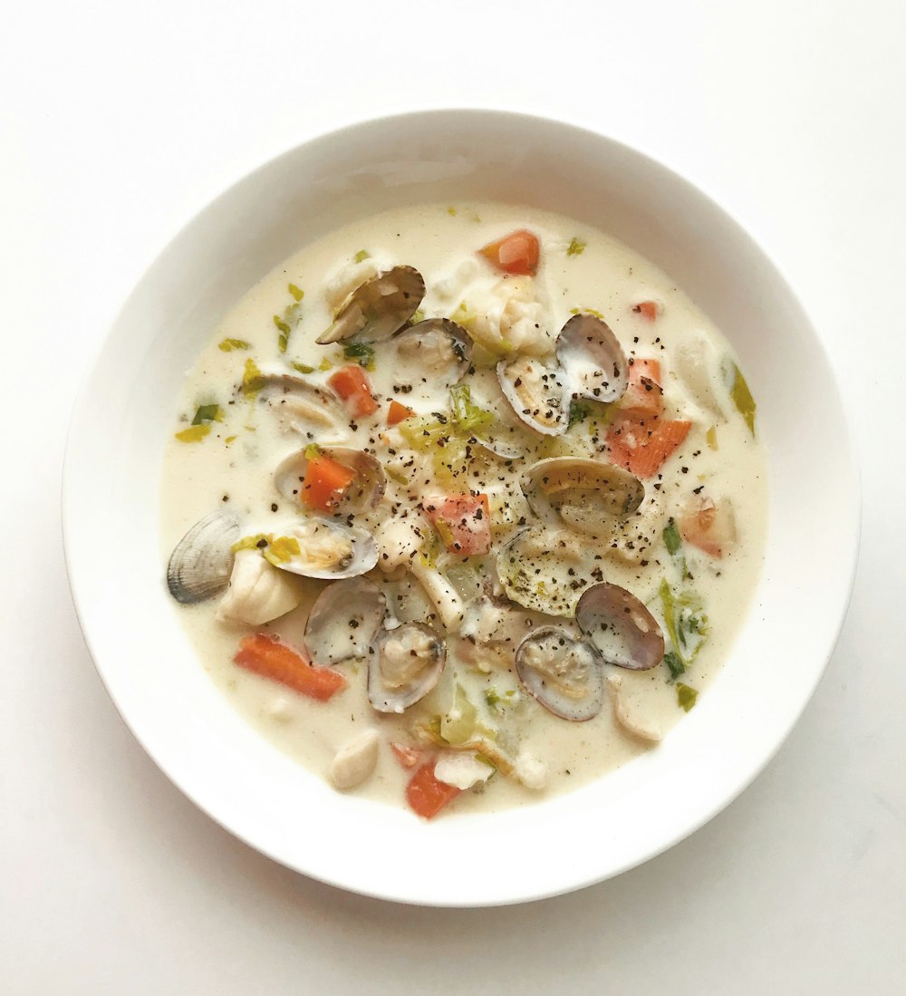 Zuppa di vongole e verdure in ciotola di ceramica bianca