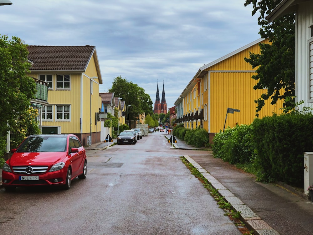 red car parked beside house