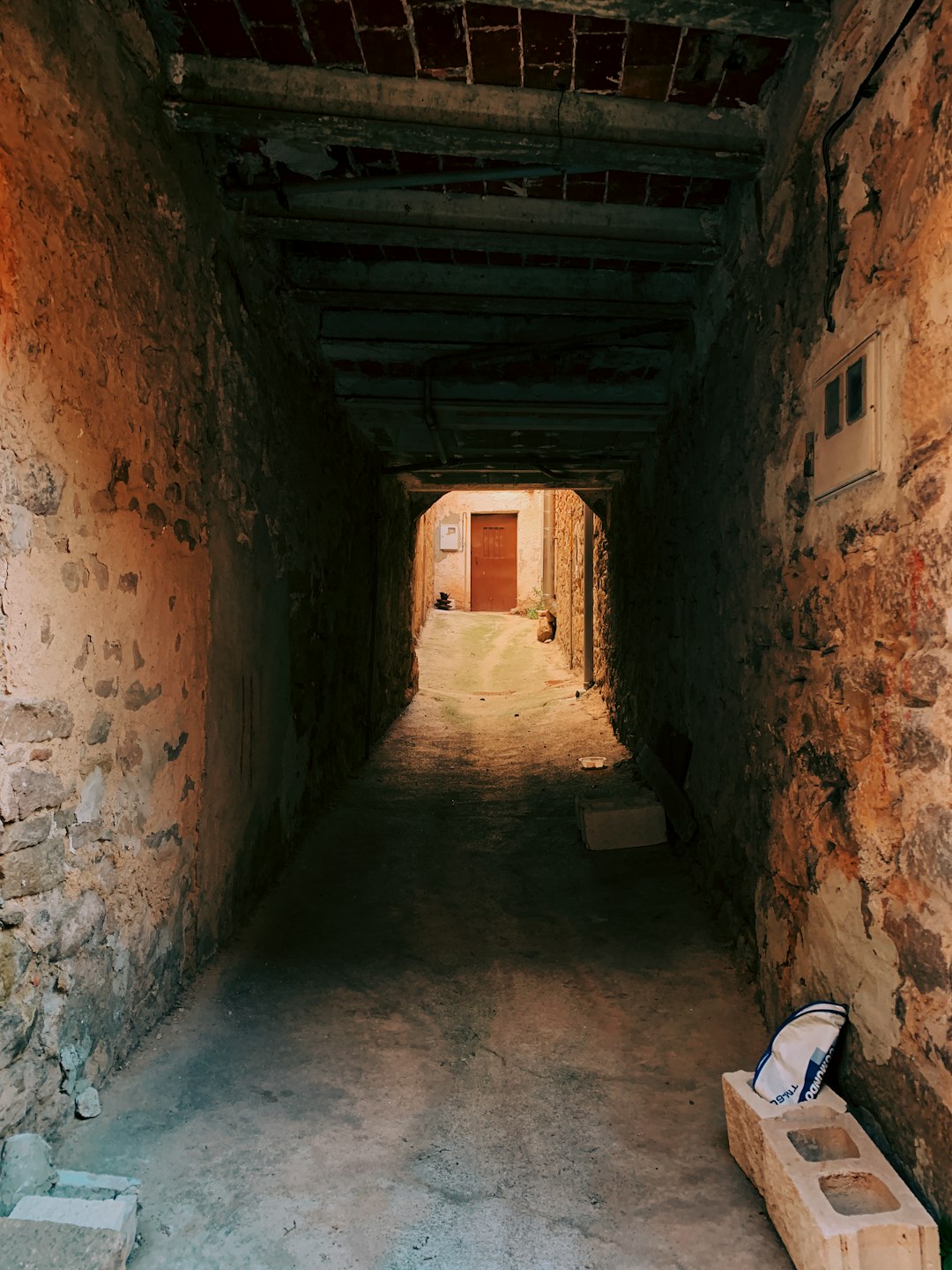 cinder block at the side of a brown stone tunnel