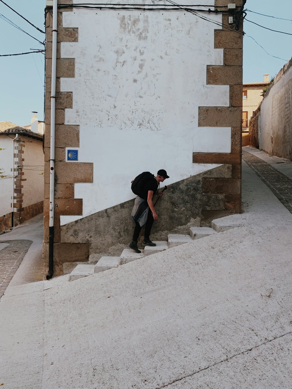 man with black backpack going up stairs