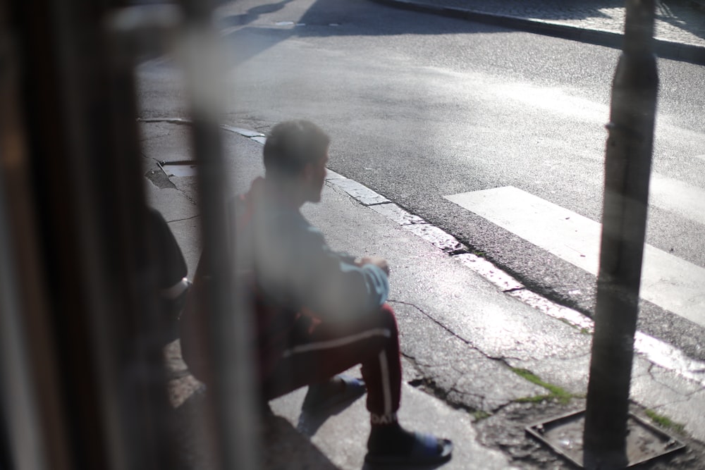 man sits in front pedestrian lane