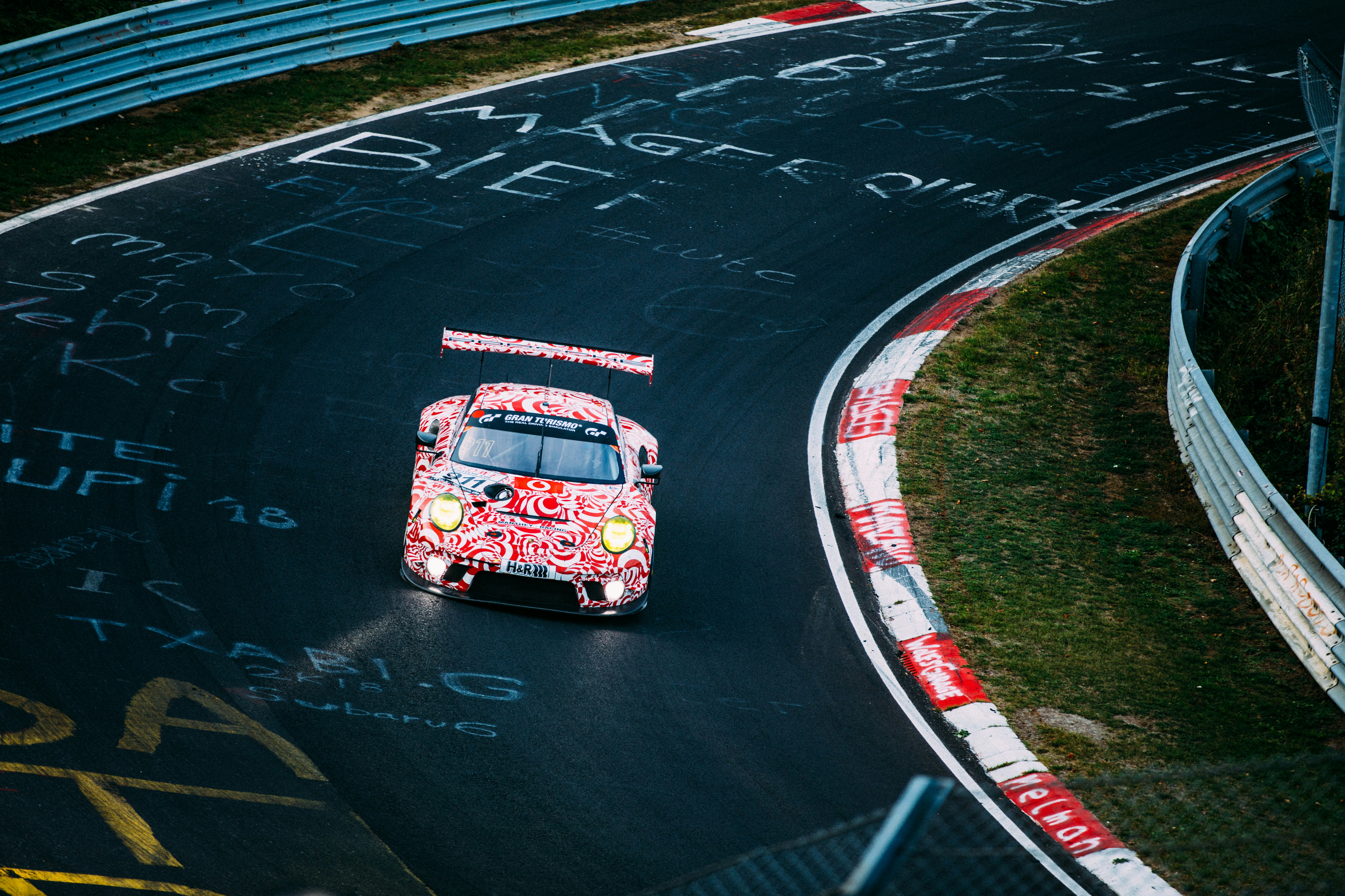 red and white racing car on road