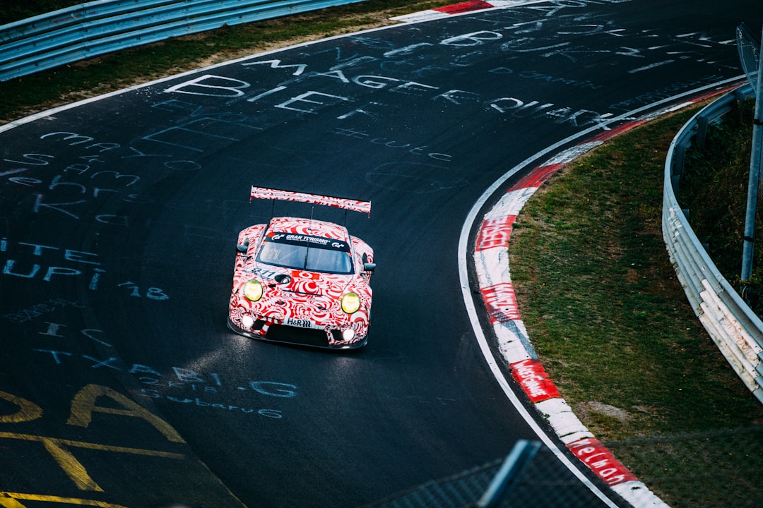red and white racing car on road,