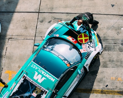 man standing in front of green and white racing car