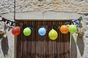 A joyful birthday celebration with colorful balloons and nature in the background