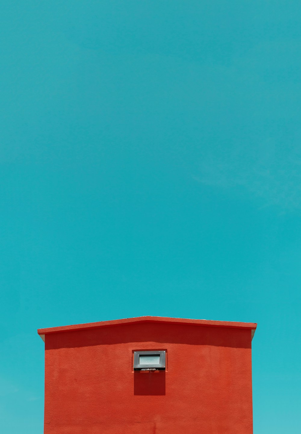 a red building with a blue sky in the background
