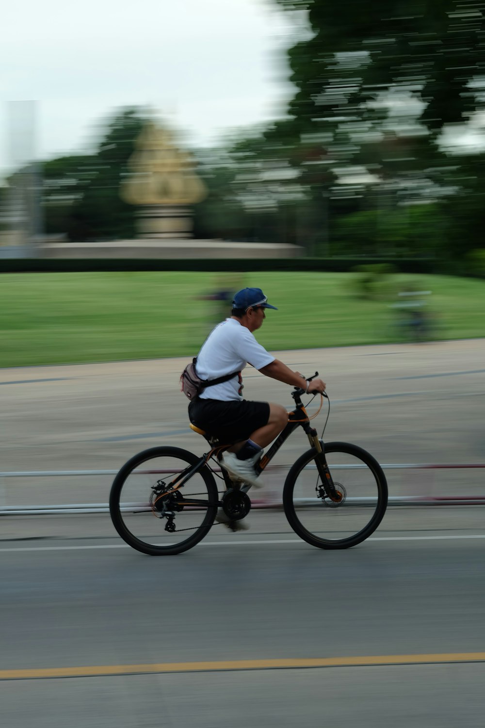 man in white t-shirt riding bicycle at the road