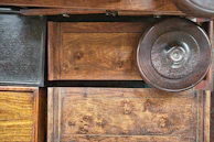 Material samples laid out on a cream surface, featuring warm wood grains, soft fabrics, and metal accents.