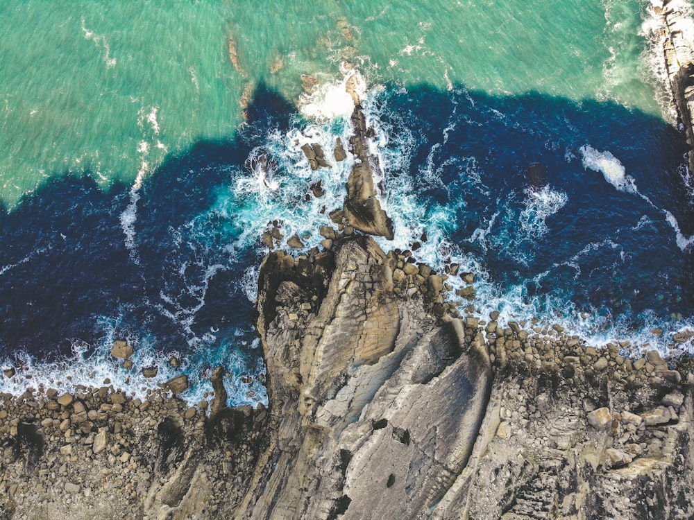 aerial photography of ocean waves crushed on rocks