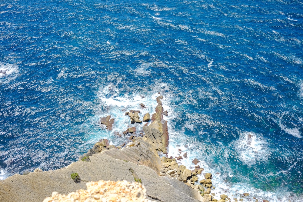 high-angle photography of rocks near body of water