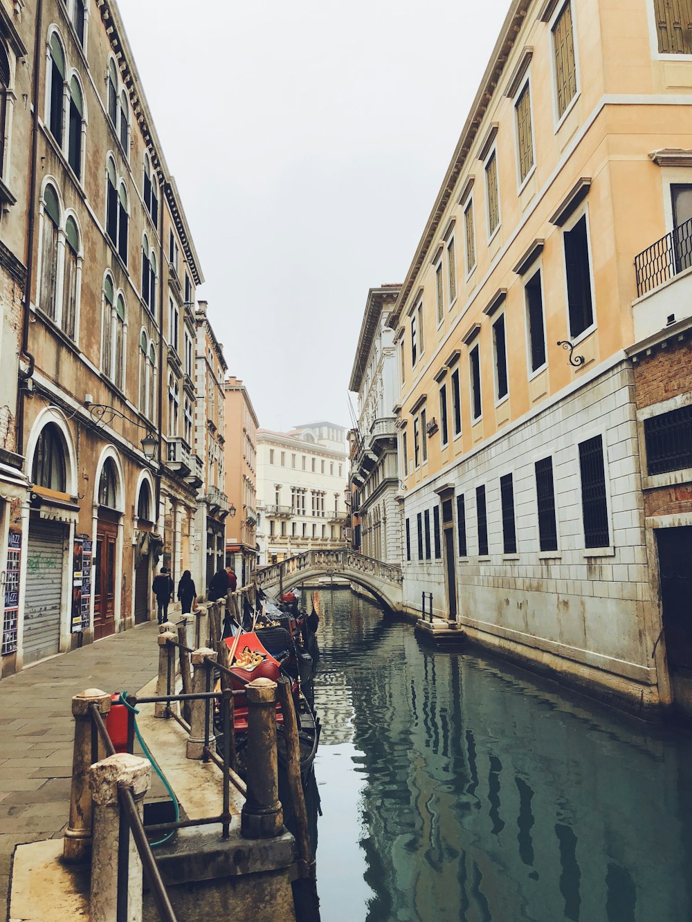 people walking in sidewalk beside canal