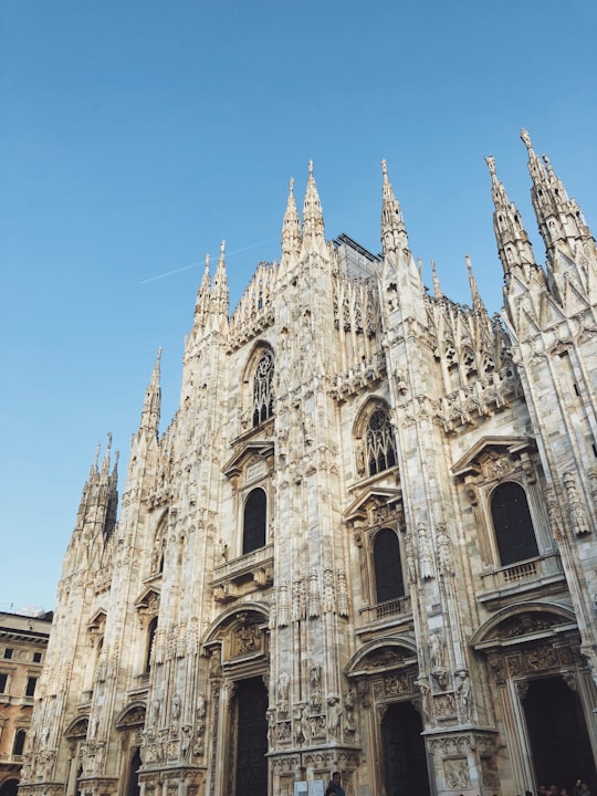 brown cathedral under clear blue sky in Duomo di Milano Italy