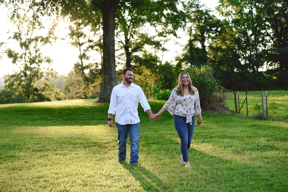 couple walking at grass lawn away from tree