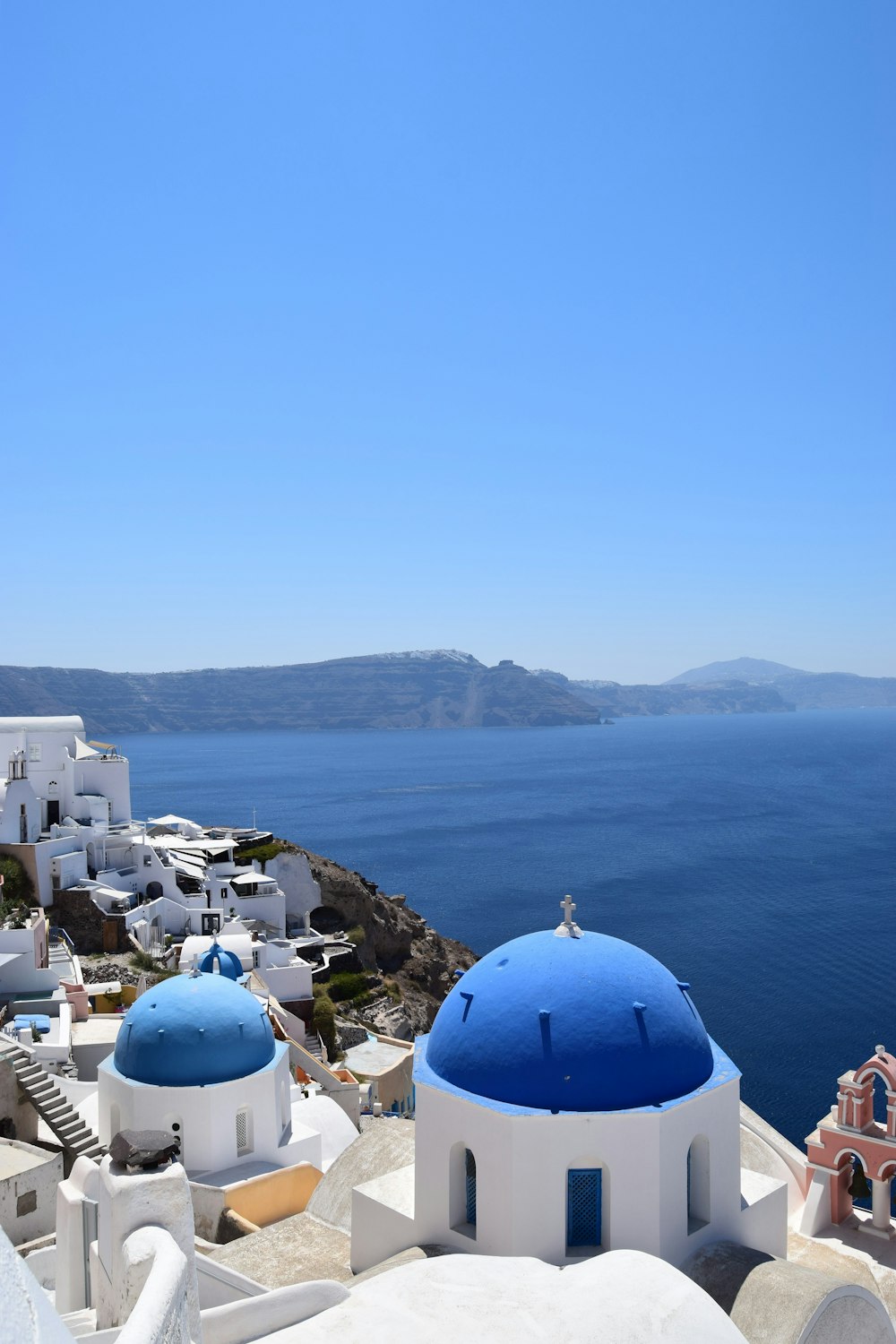 日中のサントリーニ島、ギリシャの青いドームの建物