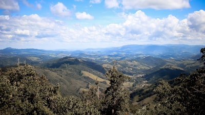 A cinematic view of a lush green landscape with mountains in the background.