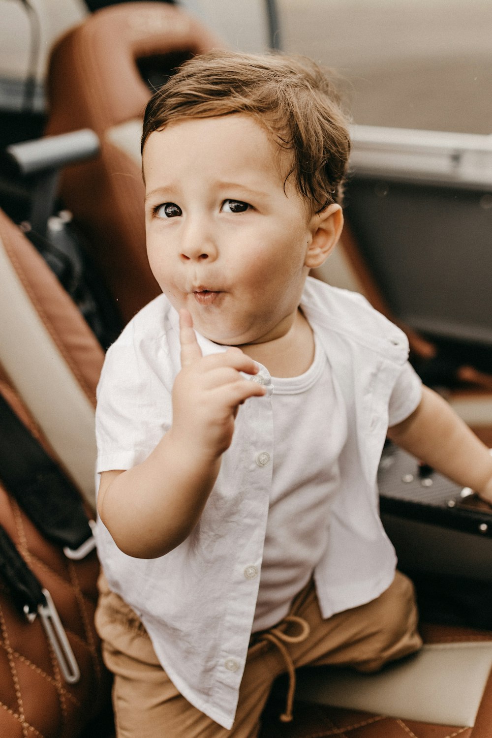 boy wearing white button-up t-shirt, white tank top and brown bottoms