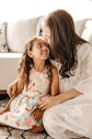 a woman sitting on the floor with a little girl