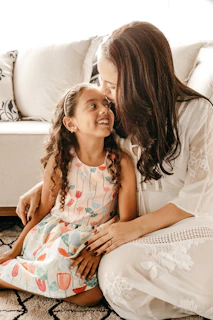 Egyptian mother and daughter wearing matching lemon wear pajamas, sitting comfortably on a cozy living room sofa.
