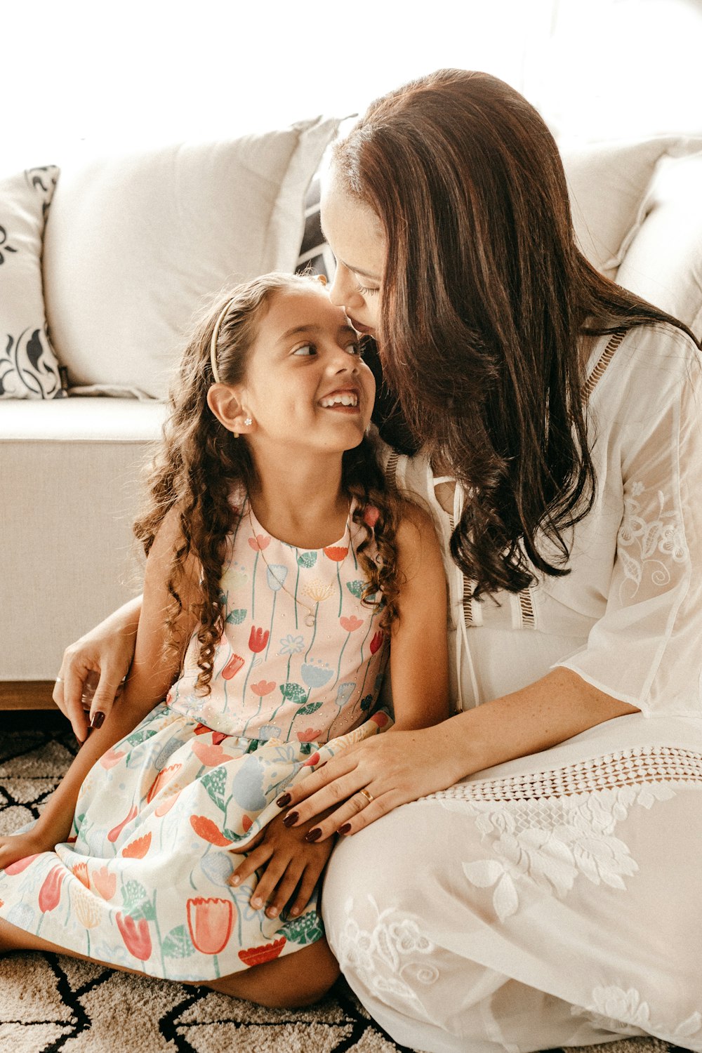 a woman sitting on the floor with a little girl