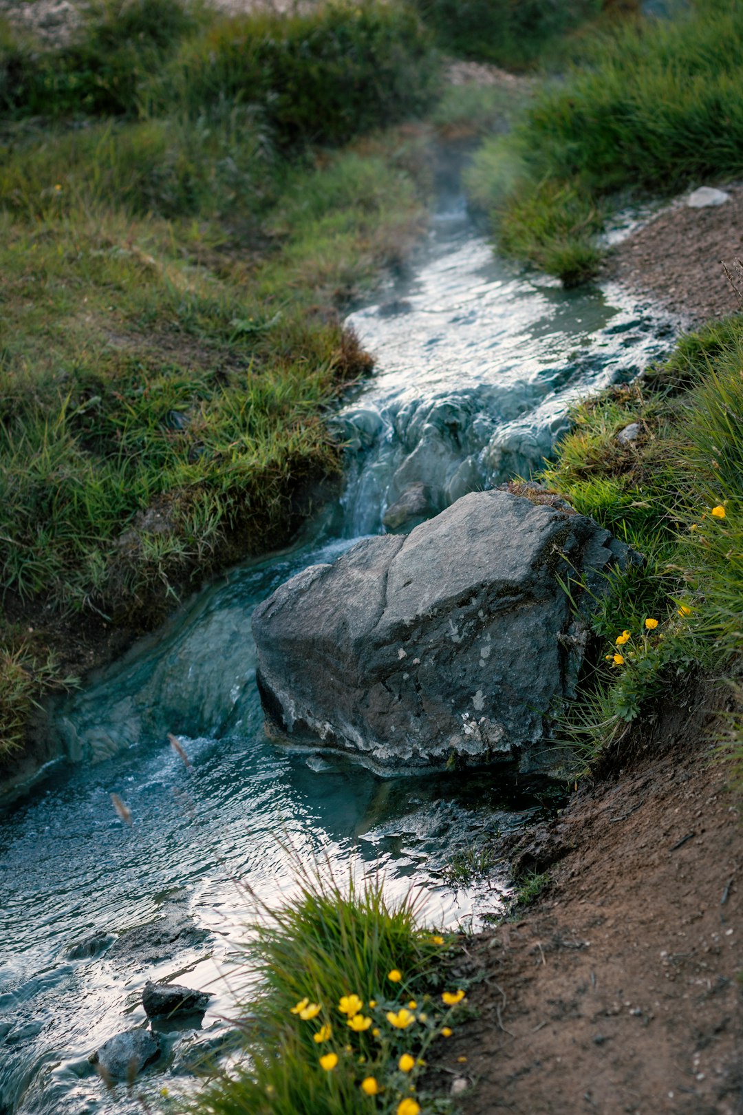 stone on stream of water during daytime