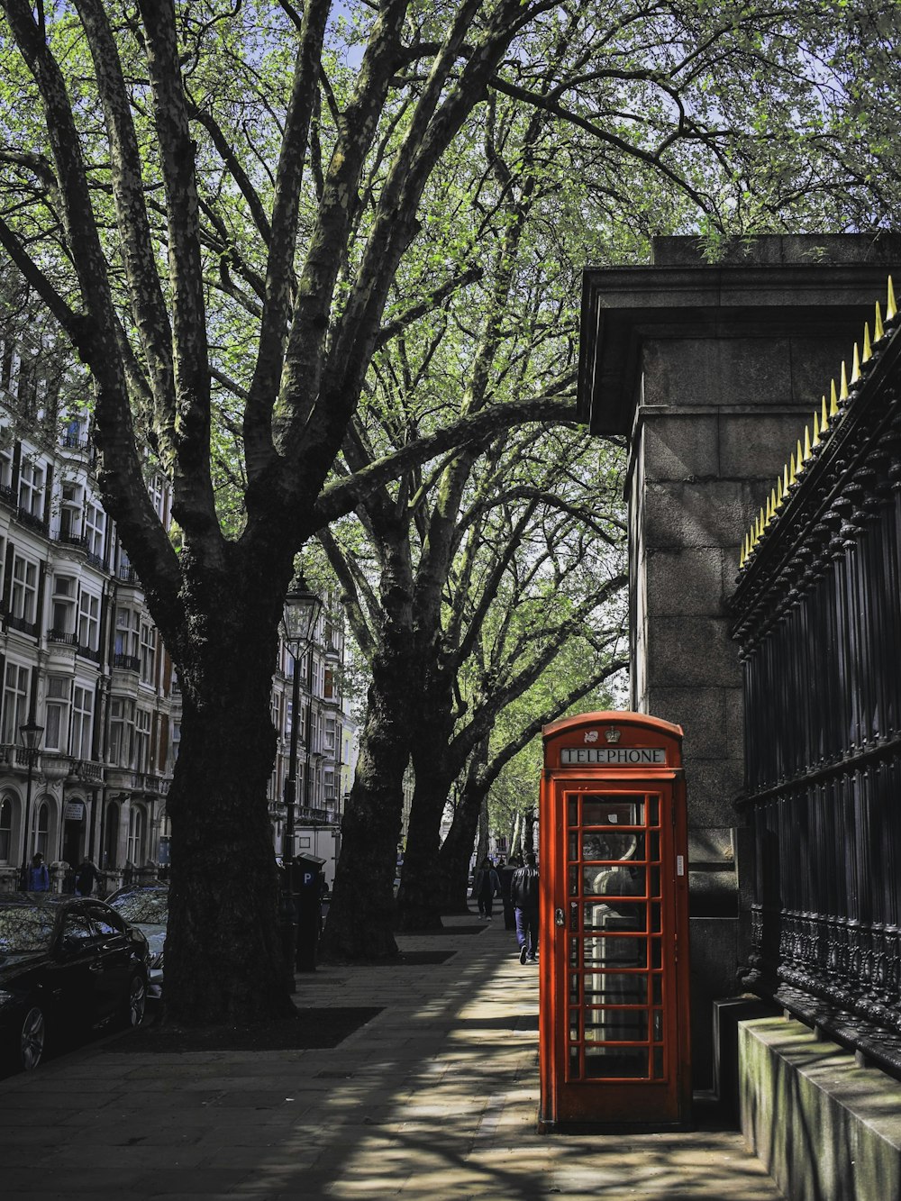 red telephone booth on a sidewalk