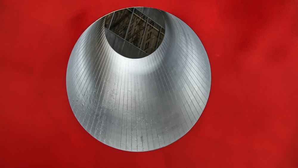 a round metal object on a red surface
