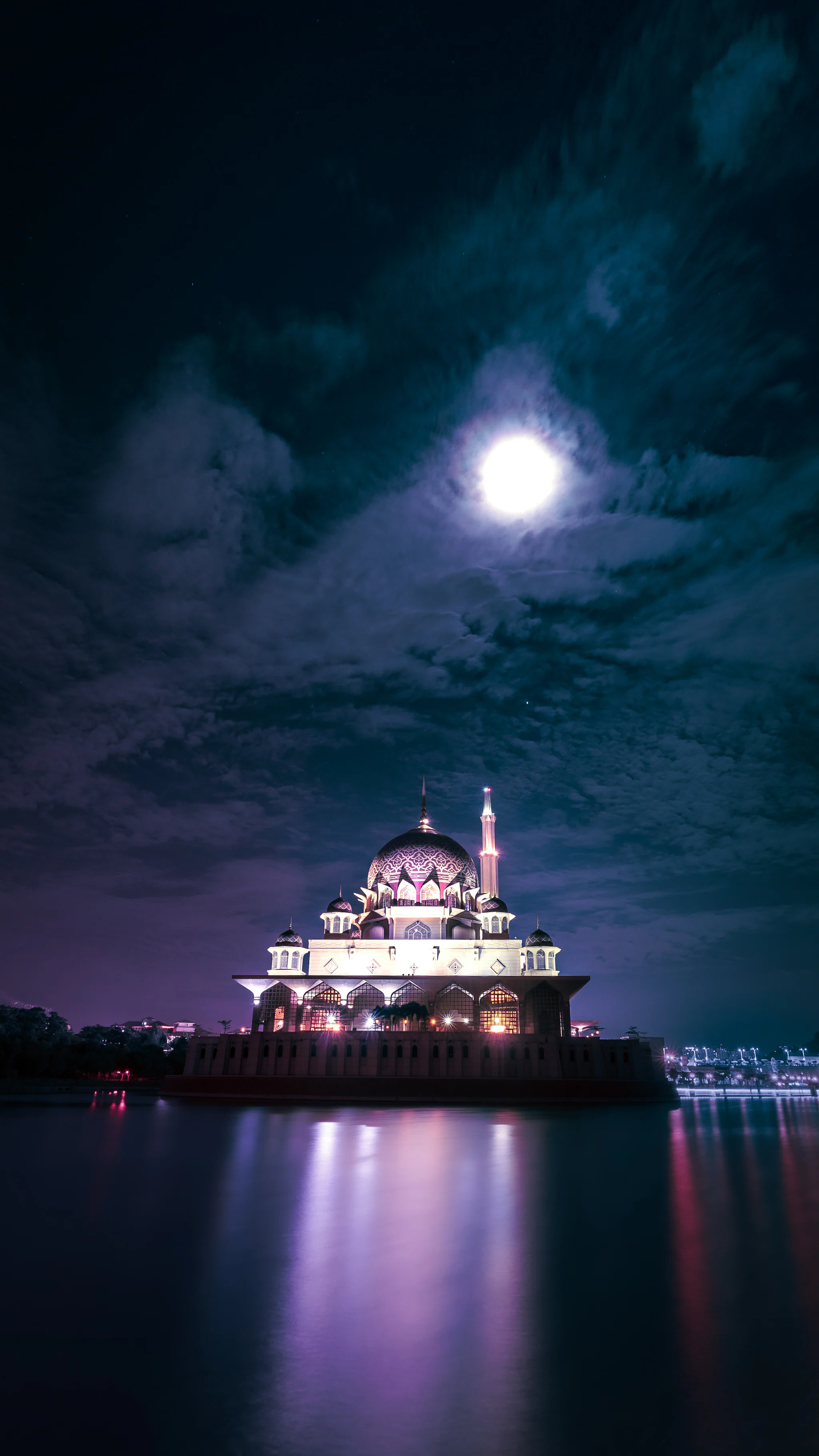 Dolunayın altında ışıklandırılmış bir cami kubbesi ve minaresi