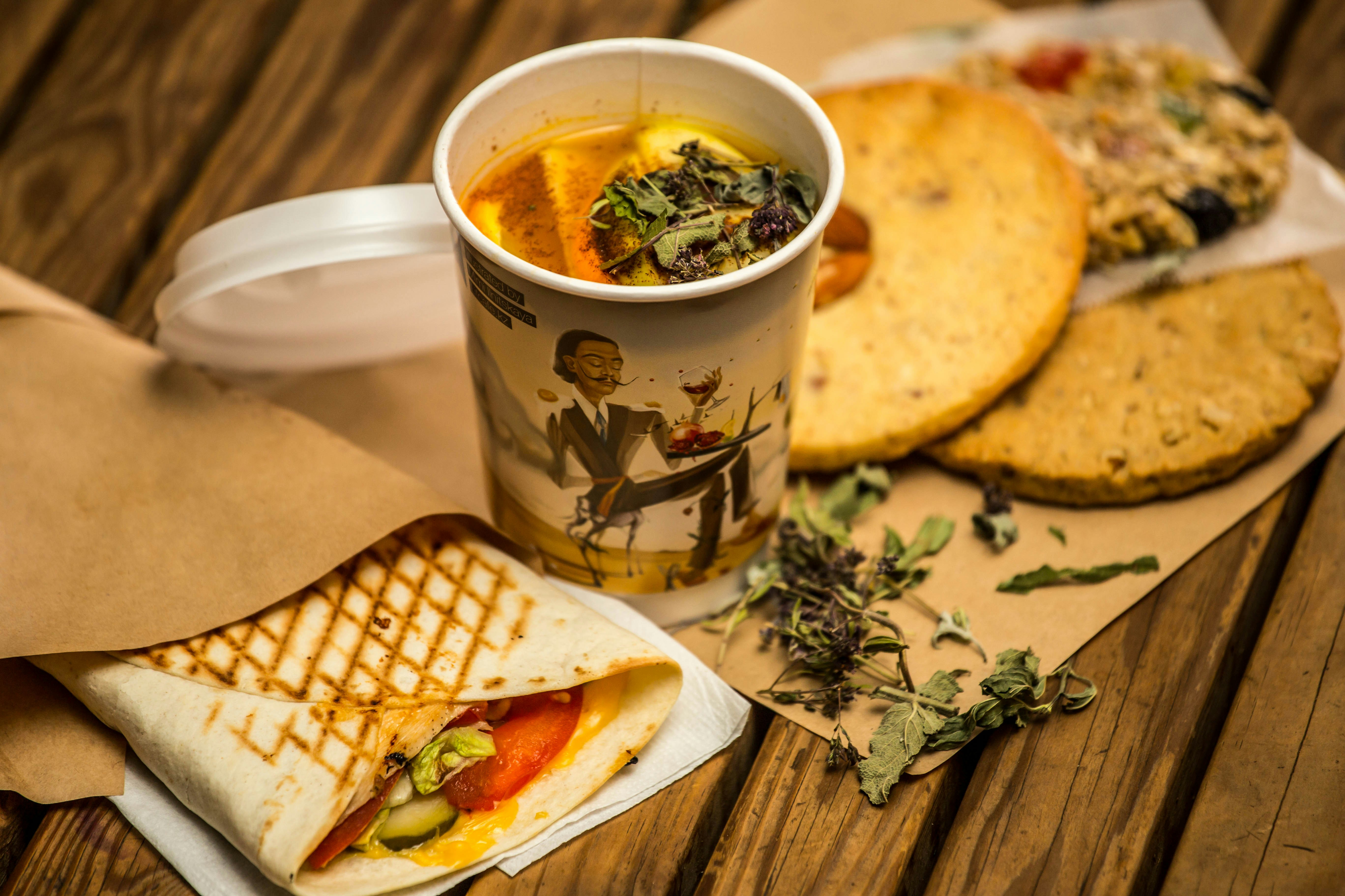 Toasted wrap and cookies beside a cup