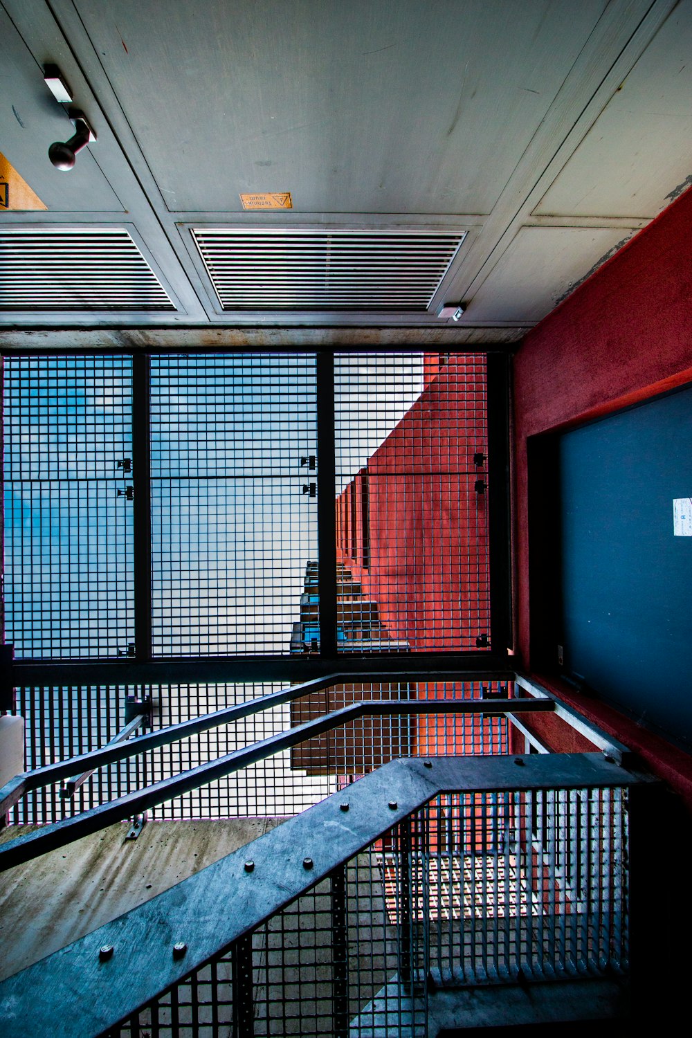 una habitación con una barandilla de metal y una pared roja