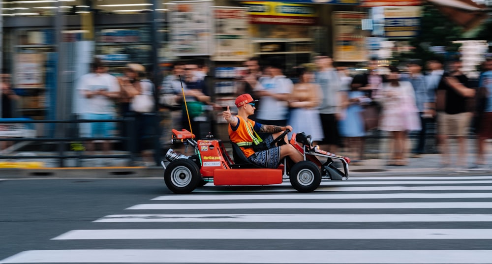 man riding go cart on pedestal lane near people watching