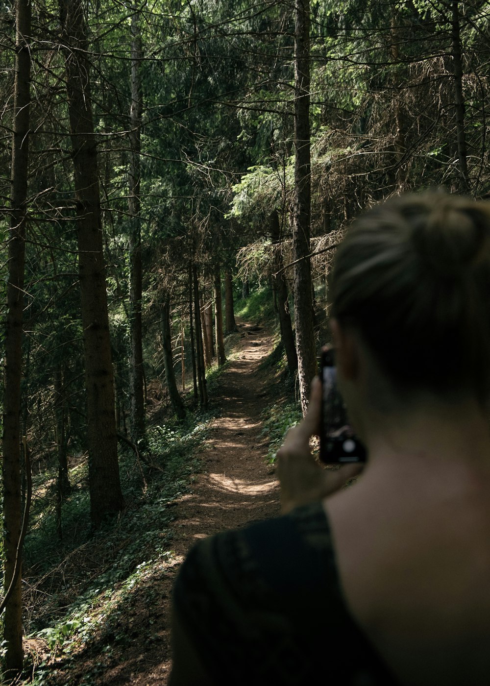 woman taking photo of trees