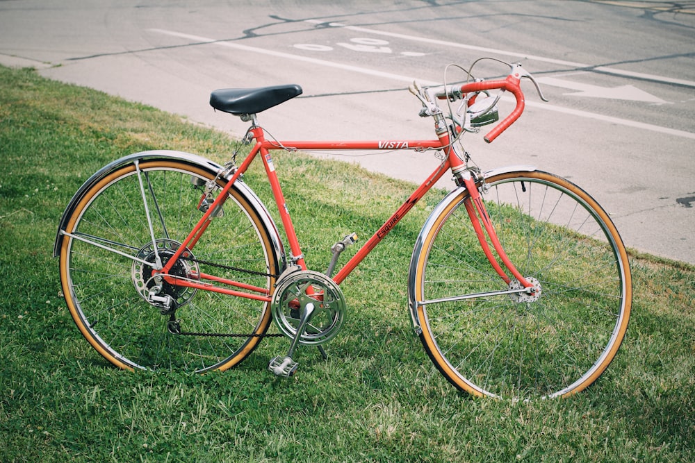 red road bike parked on grass