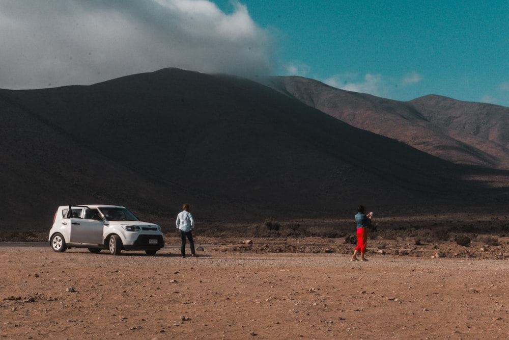 two people near SUV on desert