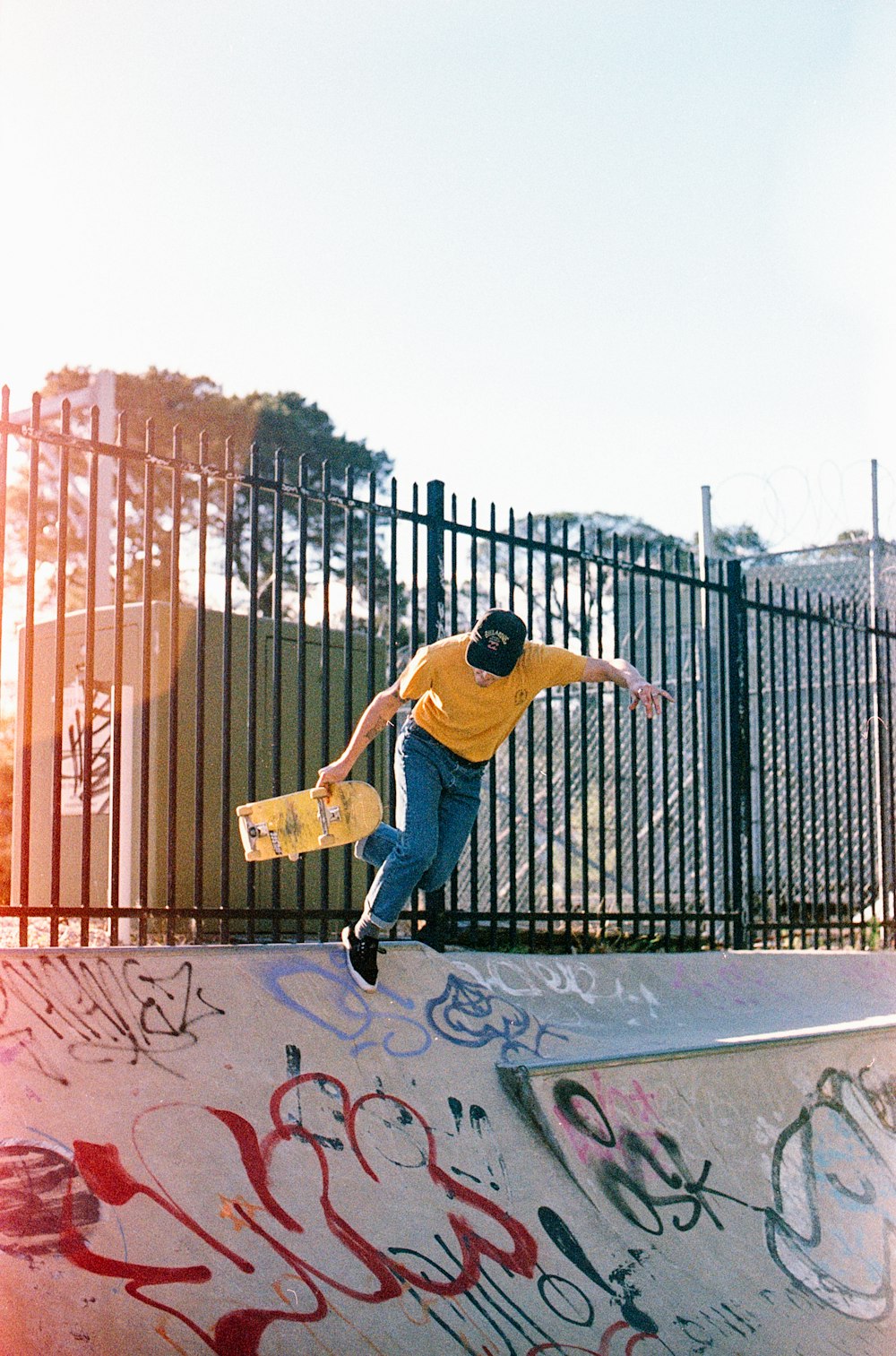 man wearing blue jeans holding skateboard