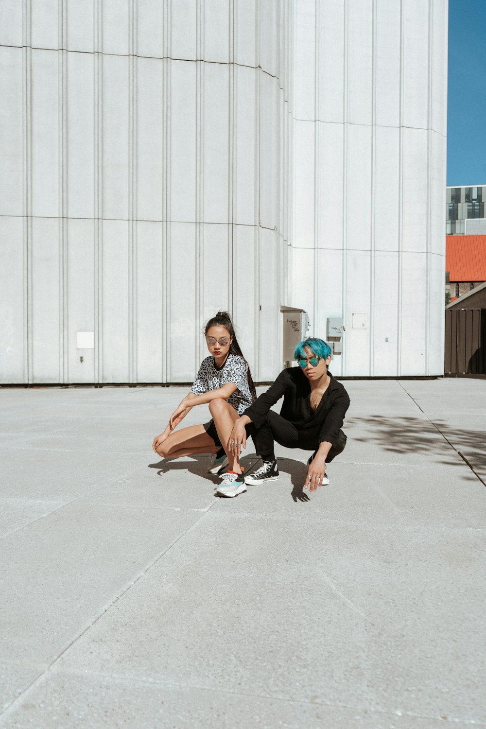 two person sitting in front of a wall during daytime