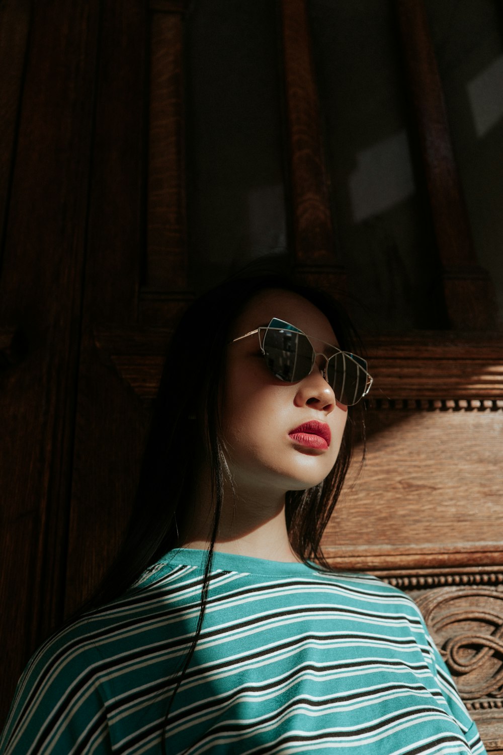 woman standing near brown wooden wall