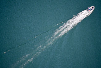 Close-up of an efoil’s polished hull cutting through deep navy blue waves.