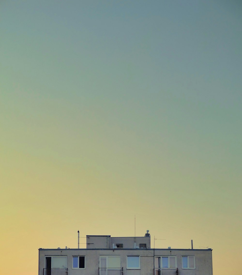 white rooftop building photo across sky