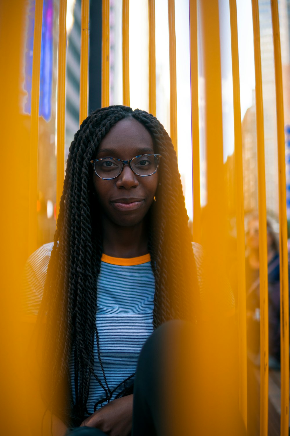 woman in white and blue striped crew-neck shirt near yellow metal bars