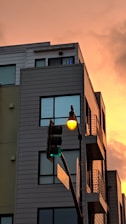 Modern residential building with commercial storefronts at street level during sunset.