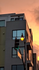 Modern residential building with commercial storefronts at street level during sunset.