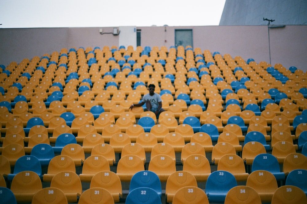 person sitting in the middle of chair lot during daytime