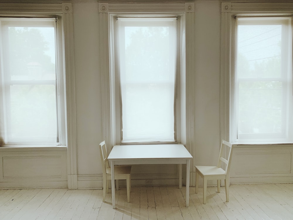 two vacant white wooden chair in room