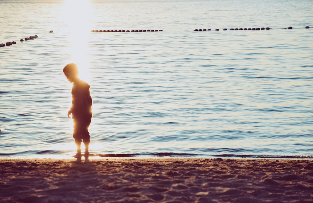 Kind steht am Strand