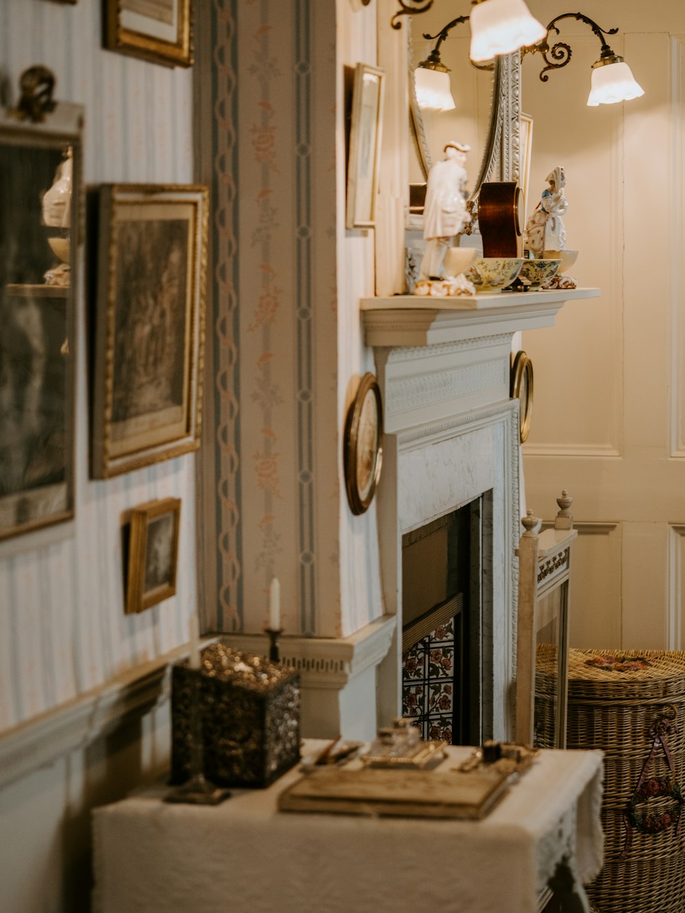 book and candle sticks on table beside the wall with photo frames