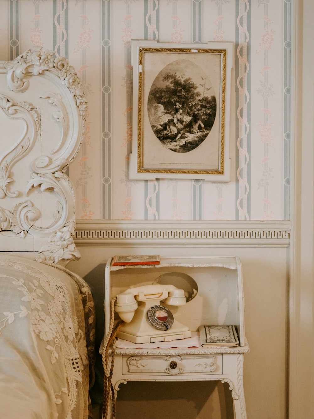 nightstand beside bed with ornate headboard