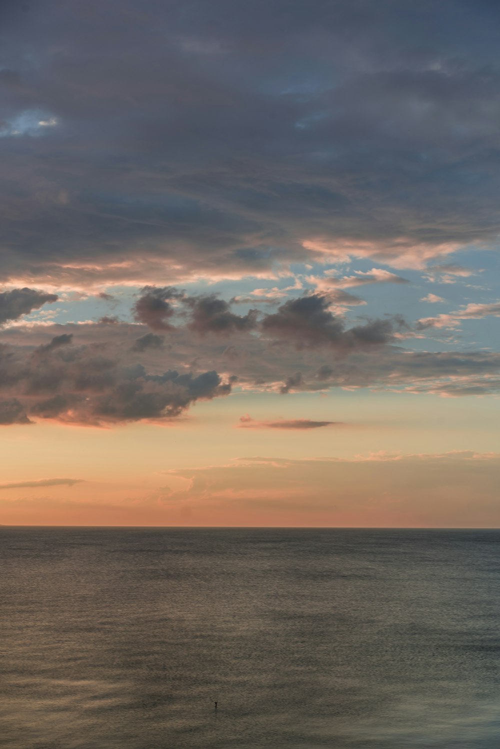 calm body of water under orange and blue skies