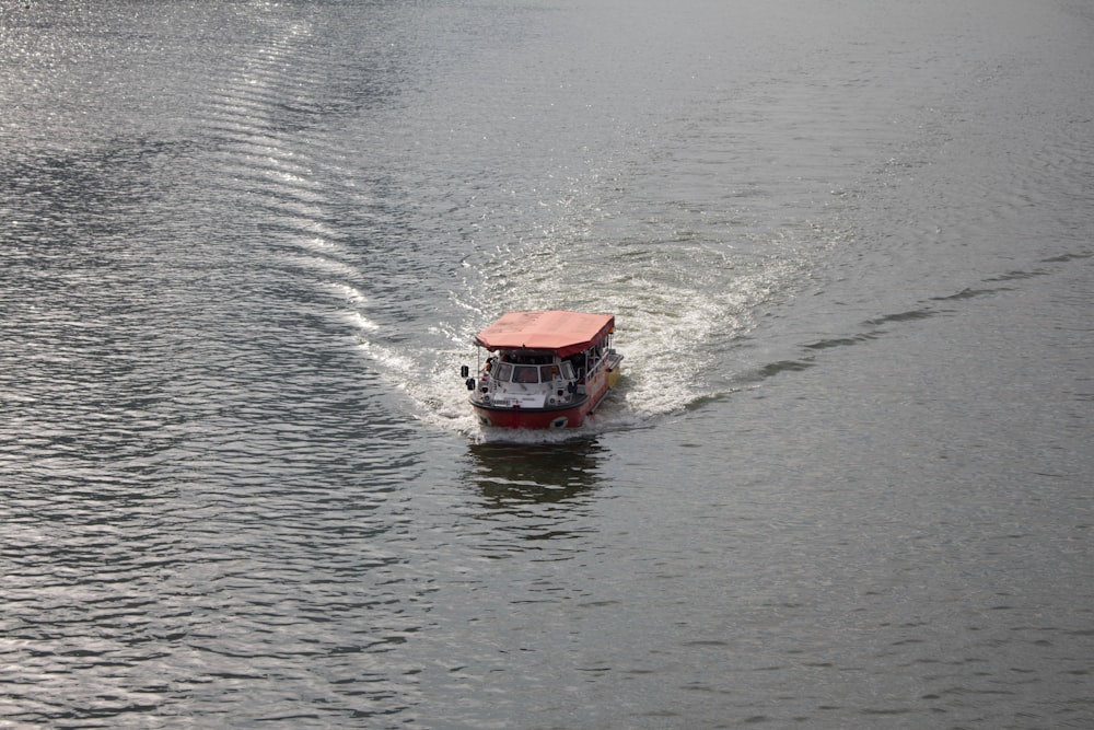 red boat travelling on the body of water