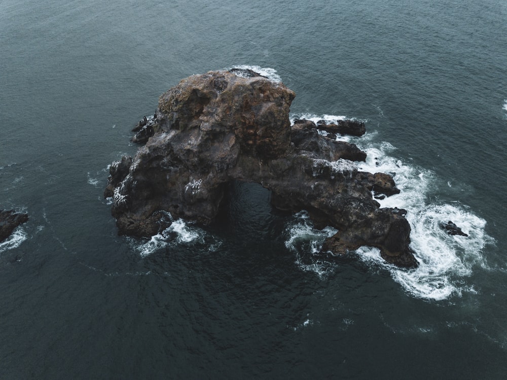 black rock surrounded by water