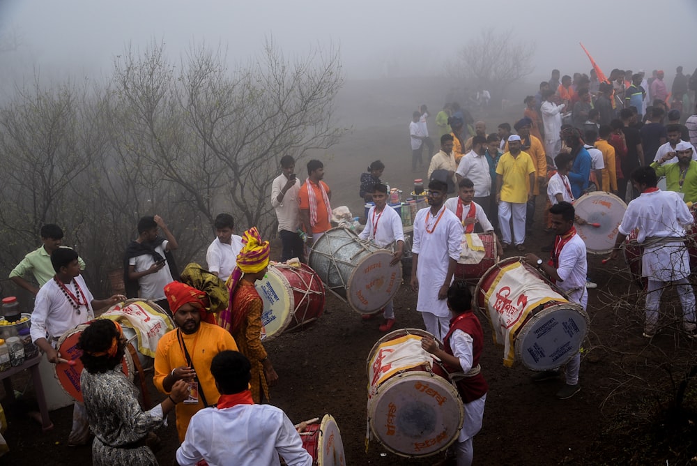 people gathering outside and playing musical drums at daytime